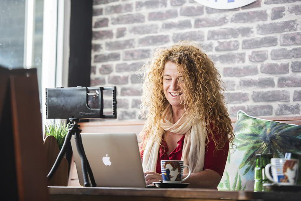 Lisa Monks writing at her laptop in a coffee shop