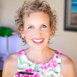 Portrait of Mari Smith smiling, wearing a floral top and hoop earrings